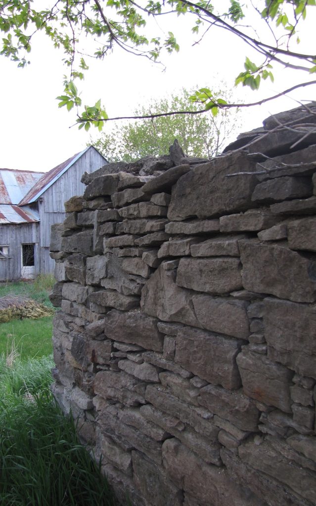 Rock wall in front of old barn